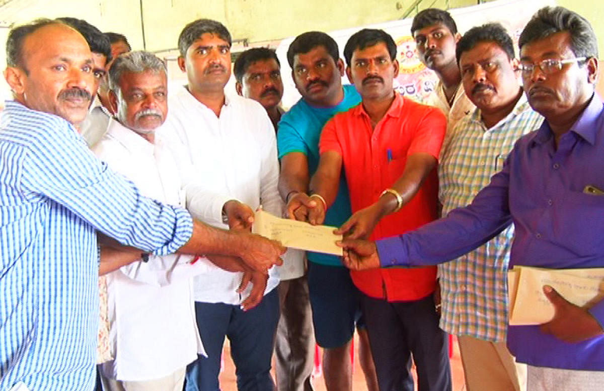 A team from Marenahalli Gram Panchayat distributes aid to flood victims in Madikeri on Sunday.