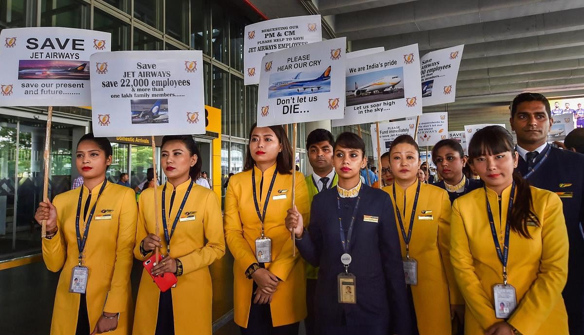 Jet Airways employees display placards during a demonstration to make an appeal for saving the cash-starved airline following the temporary shutdown of its operations, at NSCBI Airport in Kolkata. PTI file photo