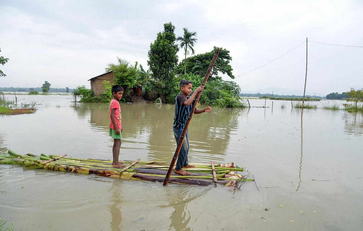 Children use a makeshift raft to cross a flood affected area after heavy monsoon rain, in Morigaon district, Assam, Friday, July 12, 2019. (PTI Photo)