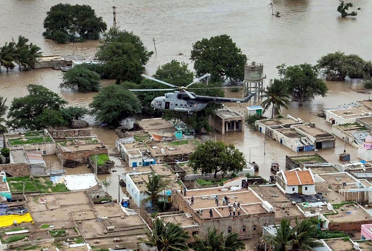 An IAF helicopter flies over a flood-affected area during a relief operation, in Belagavi. (Twitter/PTI Photo)