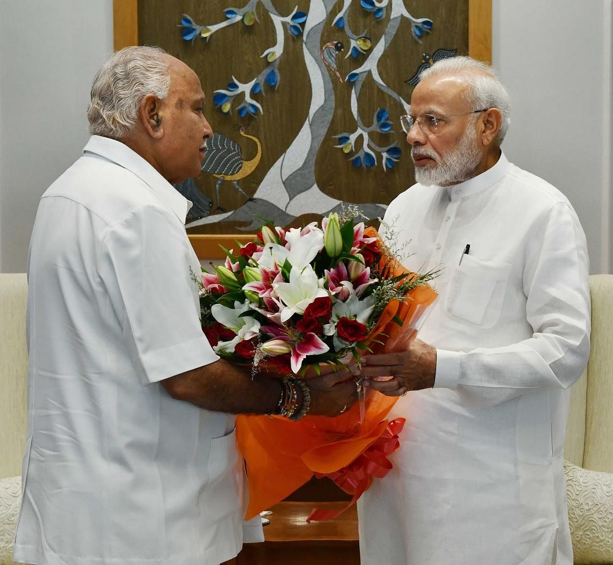 PM Narendra Modi is presented a bouquet by Chief Minister BS Yediyurappa in New Delhi on Friday. PTI