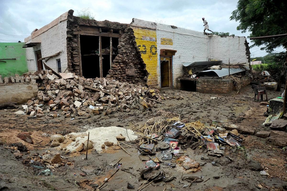 A villager atop his damaged house at Pattadakal after the recent floods. DH File Photo/Pushkar V