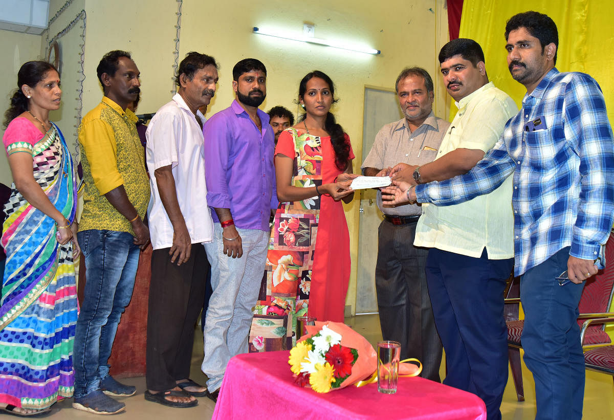 Mangaluru South MLA D Vedavyas Kamath hands over a cheque of compensation to a flood victim in Mangaluru on Monday.