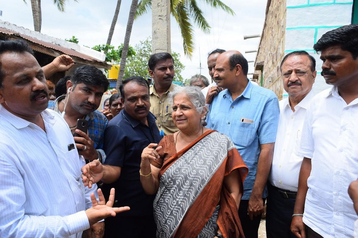 Infosys Foundation chairperson Sudha Murty interacts with the flood-affected at Konnur village in Nargund taluk of Gadag district on Friday.