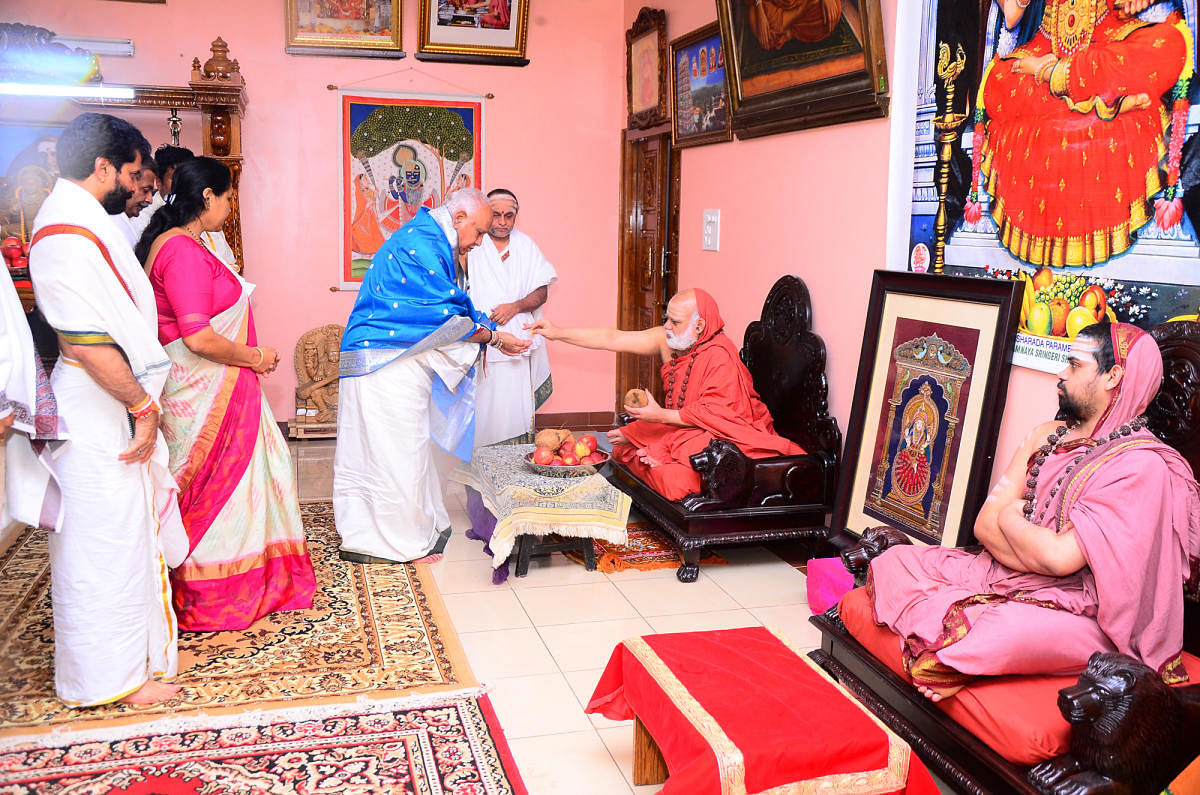 Chief Minister B S Yediyurappa receives the blessings of seer Bharathi Theertha Swami at Sringeri in Chikkamagaluru district on Thursday. MP Shobha Karandlaje and Tourism Minister C T Ravi look on. Junior pontiff Vidhushekhara Bharathi Swami is also seen.