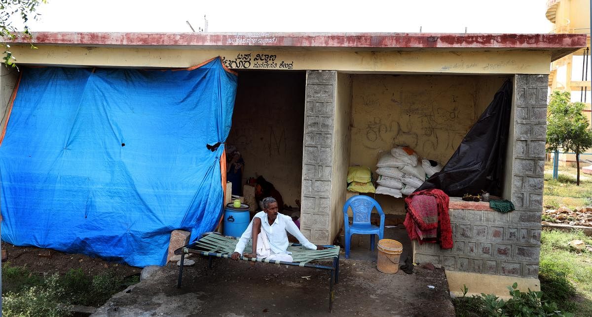 The families of Pandappa Kumbar and Hanumant Kumbar who lost their houses due to floods in Krishna river take shelter at a bus stop at Katagur in Hunagund taluk, Bagalkot district.