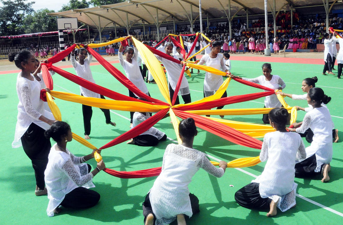 Schoolchildren present a cultural programme as a part of Karnataka Rajyotsava celebrations at Ajjarakadu Grounds in Udupi on Friday.