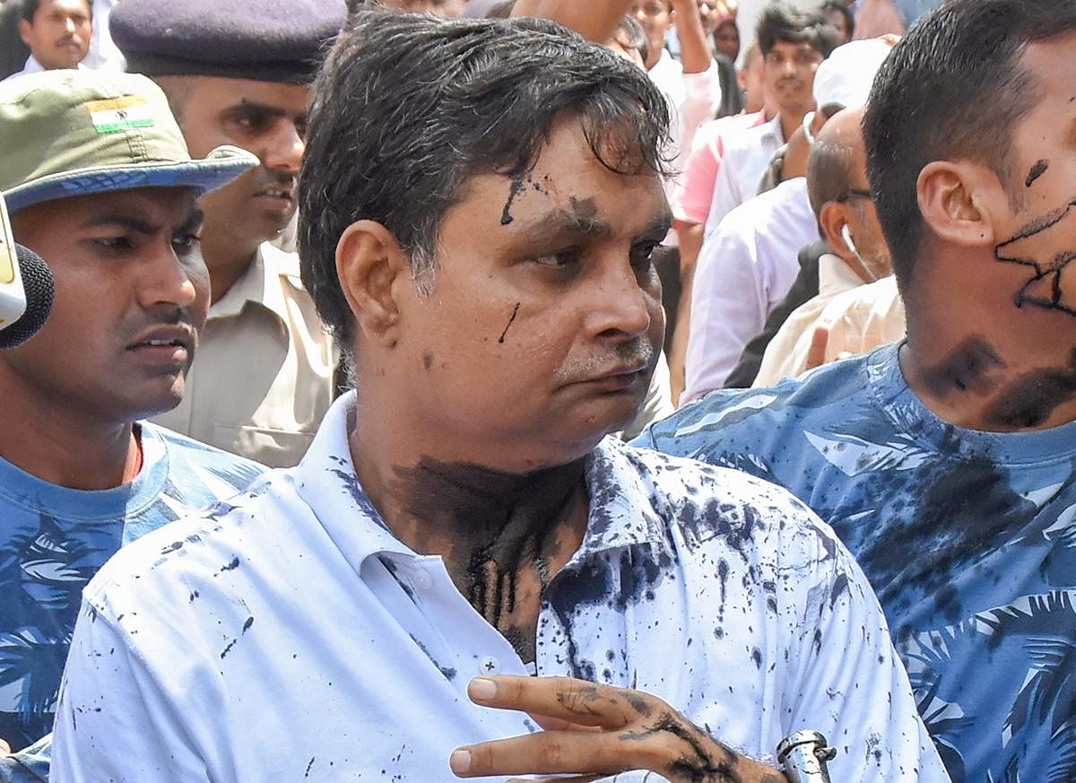 Main accused in the Muzaffarpur shelter home case Brajesh Thakur, after a woman allegedly threw ink on his face while he was being taken to a special POCSO court. (PTI Photo)