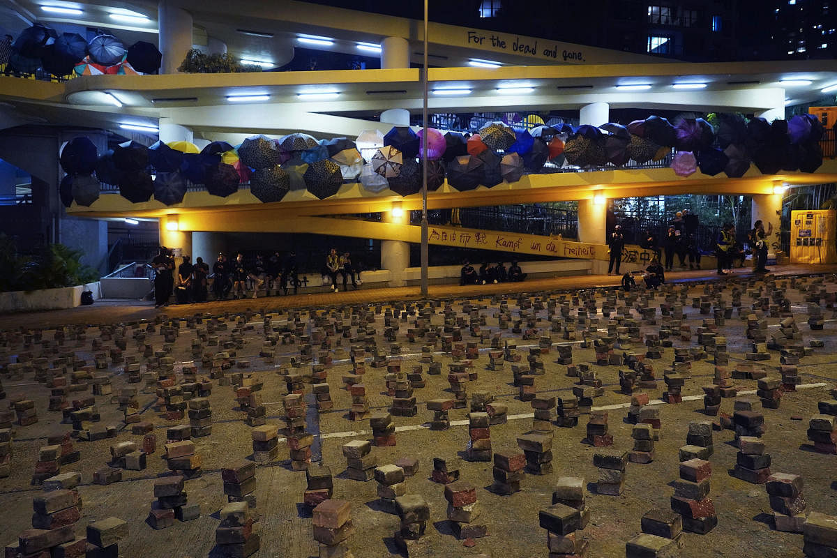 Pro-democracy protesters gather at the campus of the Hong Kong Baptist University decorated with umbrellas and bricks on the road. (AP Photo)