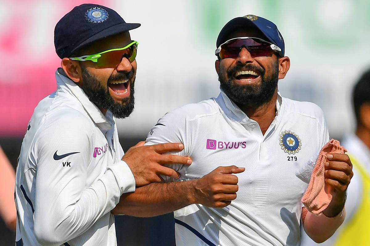 India's cricketer Mohammed Shami (R) reacts with captain Virat Kohli (Photo by AFP)