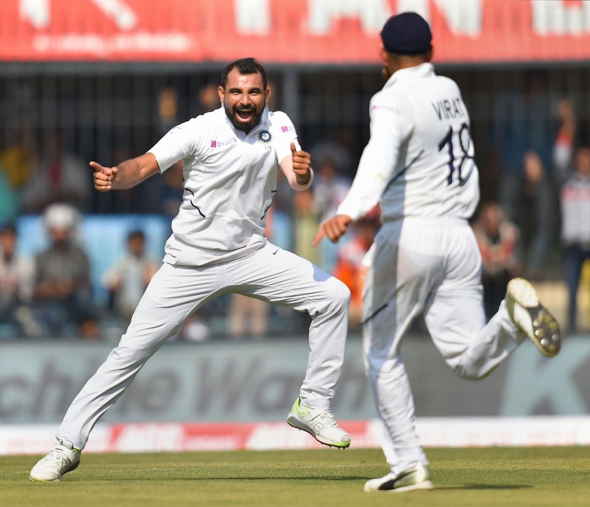 Indian pacer Mohammed Shami celebrates with skipper Virat Kohli after dismissing Bangladesh's Mushfiqur Rahim on the opening day of the first Test match  in Indore on Thursday. PTI