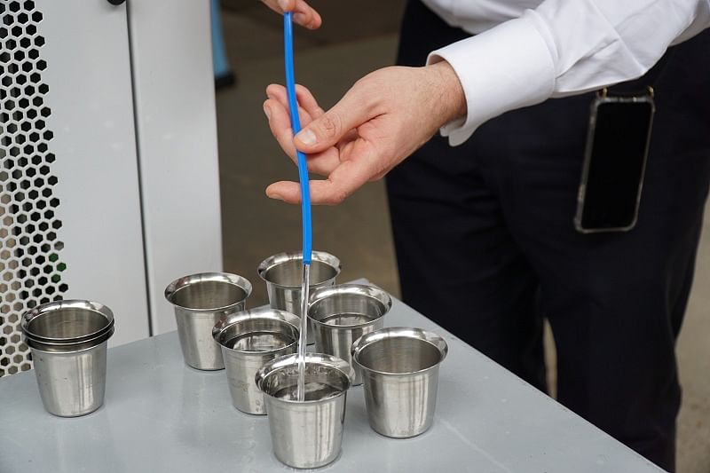 Martin Kolodziejczyk, Managing Director of Greentec Aqua, pours water extracted from the air through a complicated condensation method employed by his company's invention, the 250-litre AWA Modula, at Electronics City. (DH Photo)