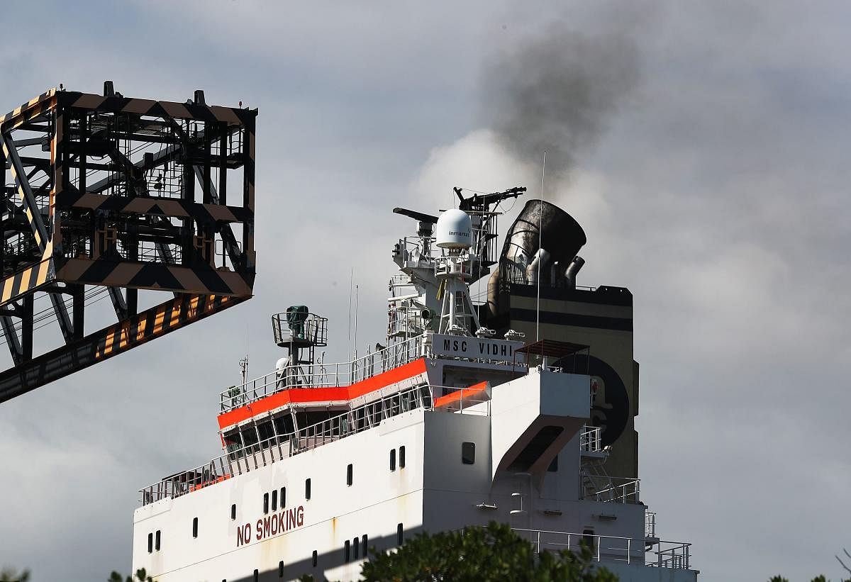 Smoke is seen pouring from the smoke stack on a container ship at Port Everglades. (Photo by AFP)