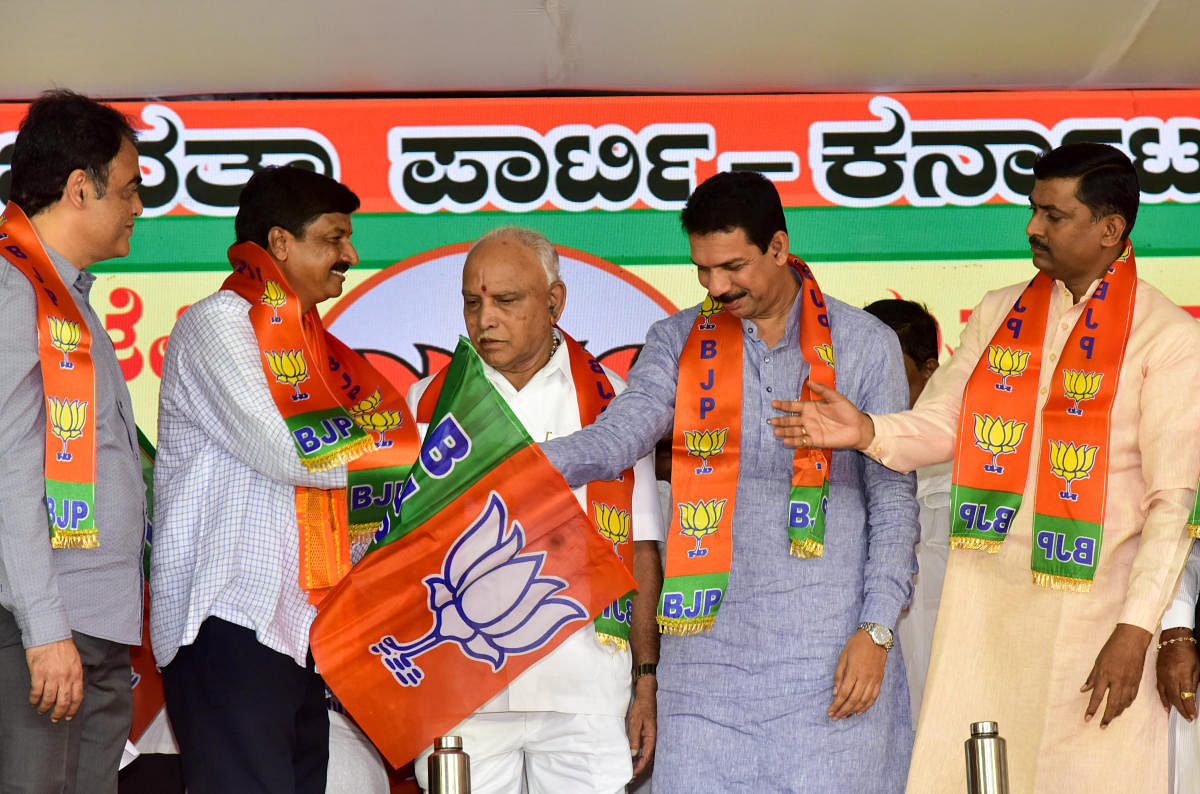 Chief Minister B S Yediyurappa (centre) and party state chief Nalin Kumar Kateel (right) welcome MLA Ramesh Jarkiholi into the party on Thursday. DH Photo/B H Shivakumar