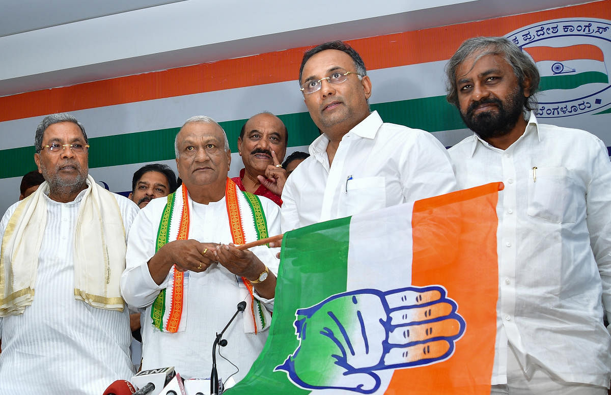 BJP rebel leader Raju Kage holds the Congress flag after it was handed over to him by KPCC chief Dinesh Gundu Rao (second from right) at a ceremony to induct him into the party in Bengaluru on Thursday. Leader of the Opposition Siddaramaiah and KPCC worki