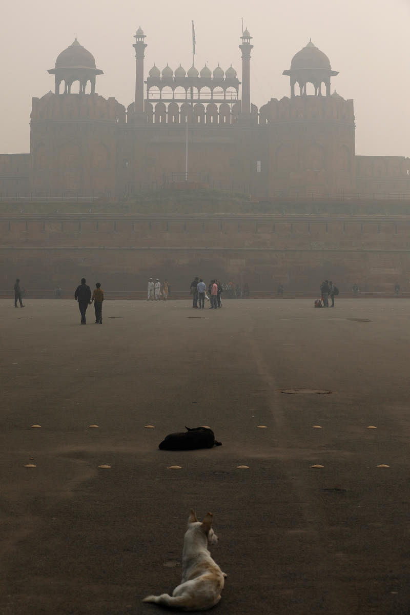 People walk outside the Red Fort on a smoggy morning in the old quarters of Delhi, India. (Photo by Reuters)