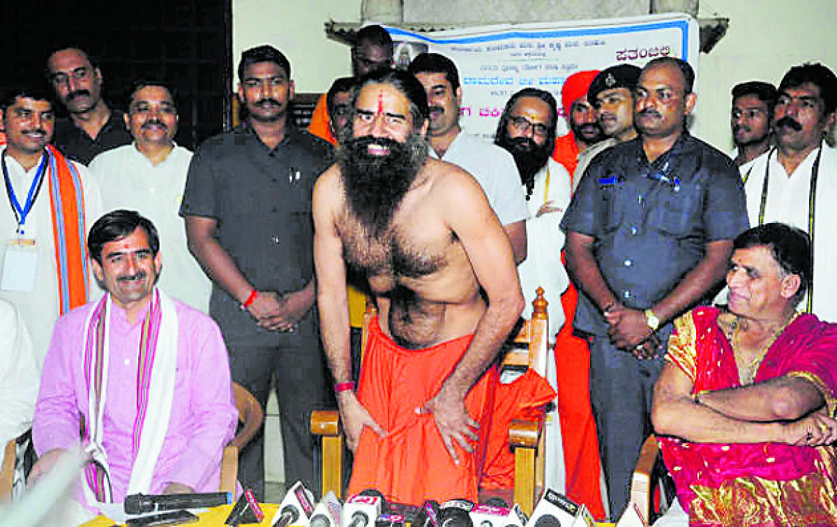 Yoga guru Baba Ramdev demonstrates an ‘Asana’ while addressing mediapersons in Udupi on Friday evening.