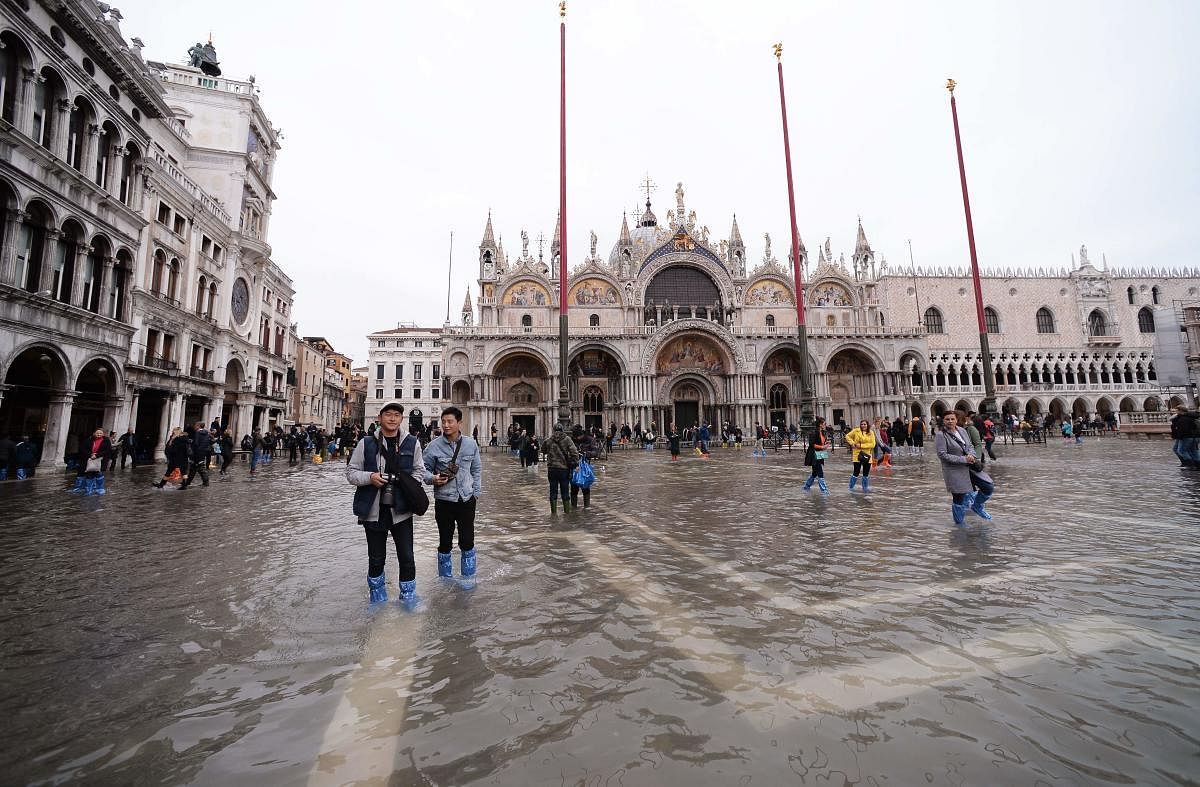 Tourists walks in St. Mark square on November 16, 2019 in Venice, three days after the city suffered the highest tide in 50 years. (Photo by Filippo MONTEFORTE / AFP)