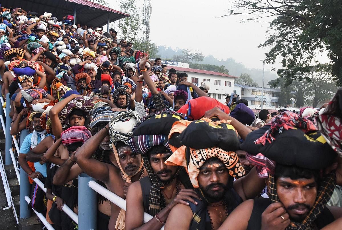Devotees stand in queues to offer prayers at the Lord Ayyappa temple during the two-month long Mandala-Makaravillakku pilgrimage season, in Sabarimala. (PTI Photo)