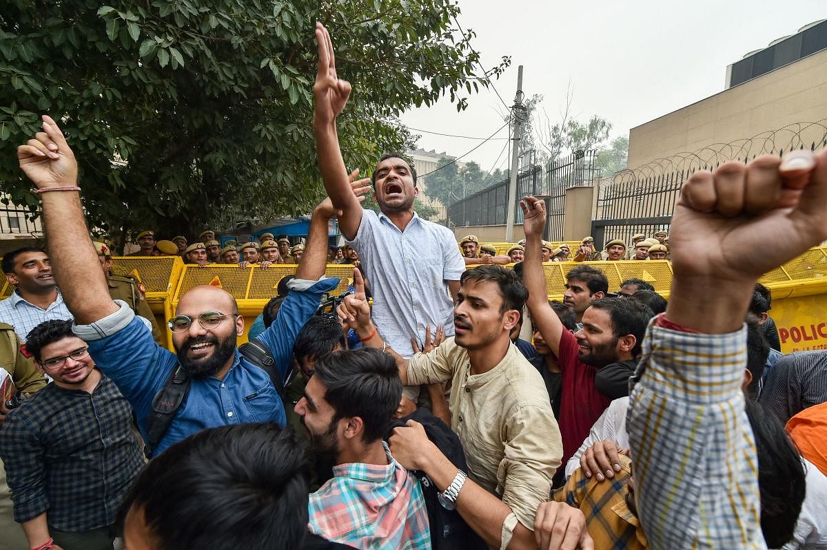JNU students celebrate after partial roll-back in the fee hike by the University administration, at the UGC office at ITO in New Delhi, Wednesday, Nov. 13, 2019. (PTI Photo)