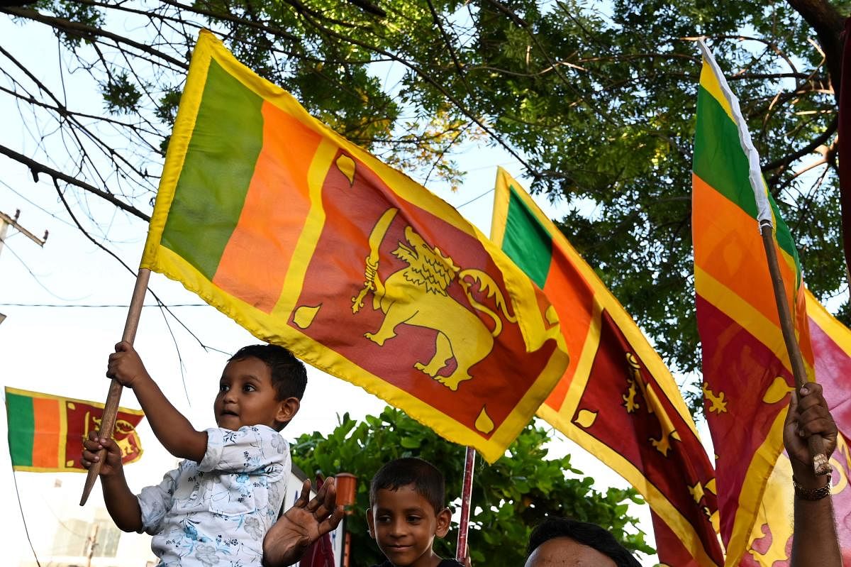 Gotabaya Rajapaksa supporters wave national flags near the election commission office in Colombo on November 17, 2019. (Photo by Reuters)