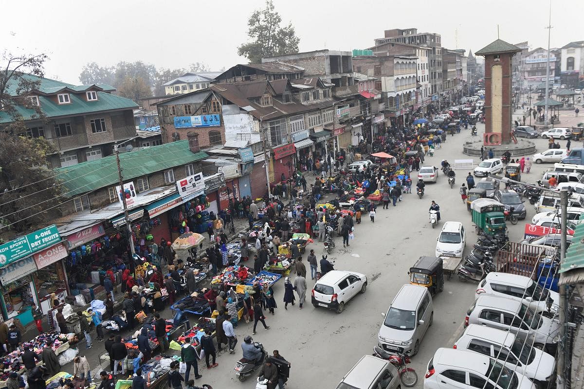 People shop at a market in Srinagar. (PTI Photo)