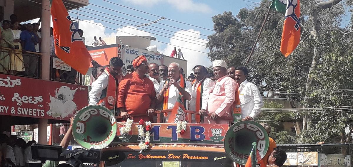 hief Minister B S Yediyurappa takes part in a procession taken out before BJP candidate M T B Nagaraj filed nomination papers from Hoskote on Monday. Nagaraj, Minister R Ashoka and party leader Katta Subramanya Naidu look on. DH photo