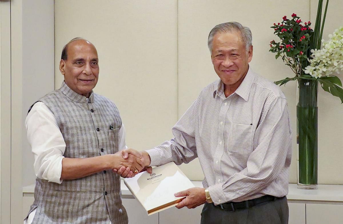 Defence Minister Rajnath Singh sakes hands with Defence Minister of Singapore NG Eng Hen at the luncheon meeting, in Singapore on Tuesday. (PTI Photo)