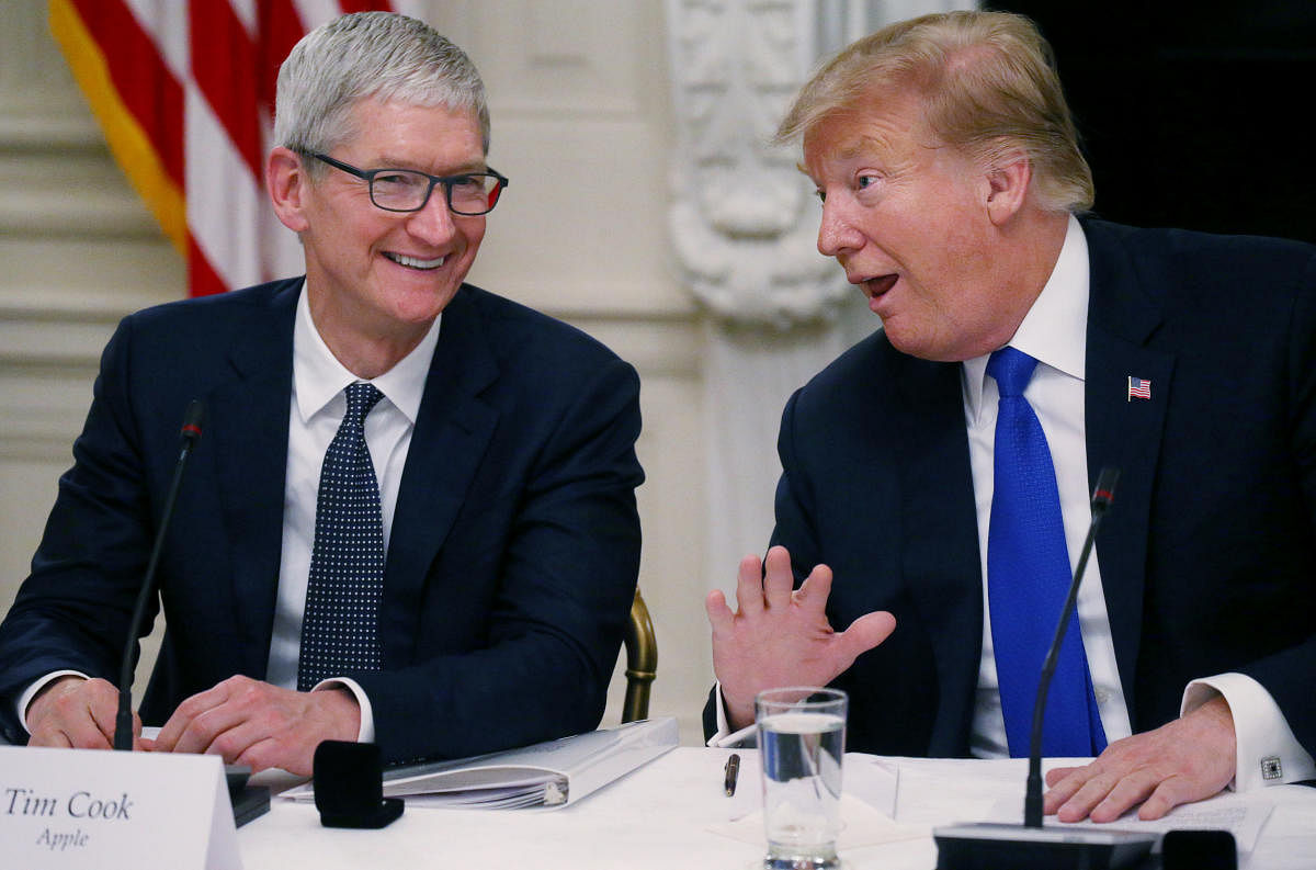 Apple CEO Tim Cook laughs with U.S. President Donald Trump. (Photo by REUTERS)