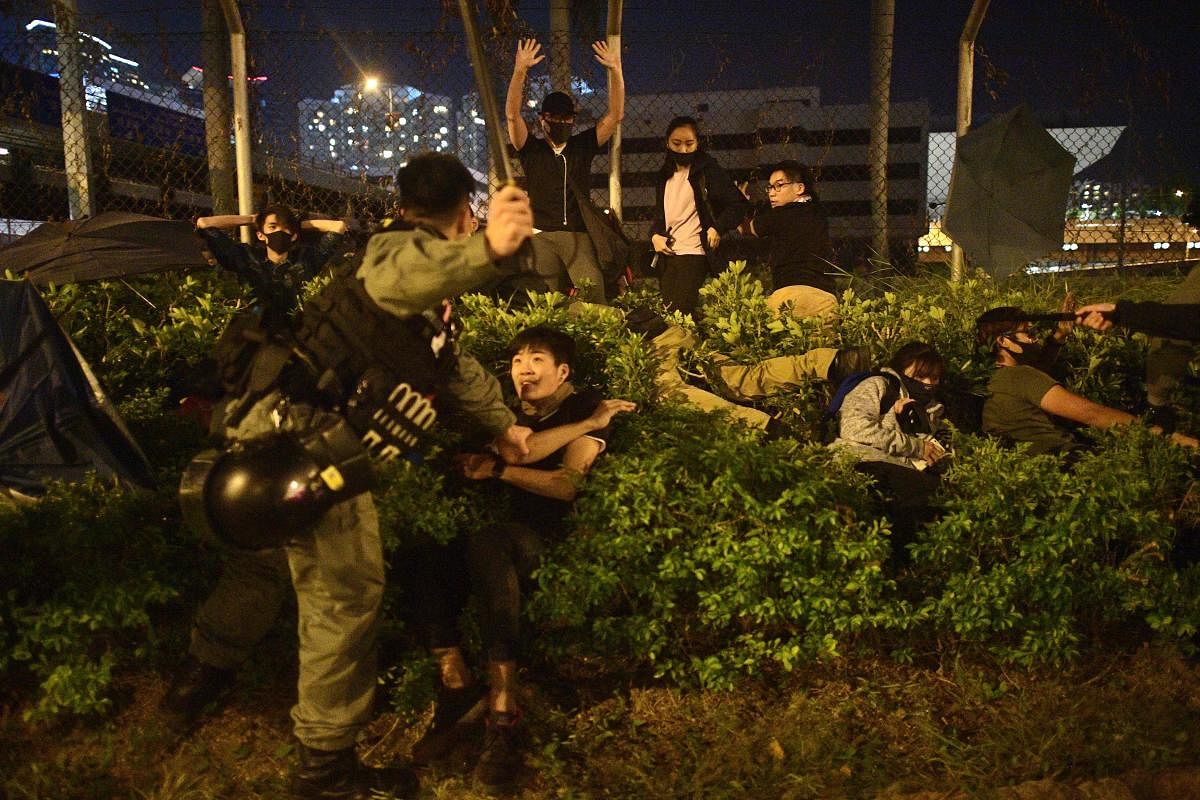 Police detain protesters and students after they tried to flee outside the Hong Kong Polytechnic University campus in the Hung Hom district on November 19, 2019. 