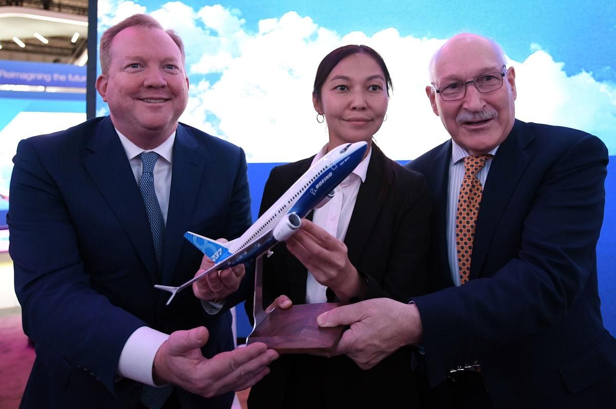 Stanley Deal (L), President and Chief Executing Office at Boeing, poses for a picture with Alma Aliguzhinova (C), Chief Planning Officer at Air Astana, and Anthony Regan (R), Chief Operating Officer at Air Astana, after signing an agreement in Dubai. (Photo by AFP)