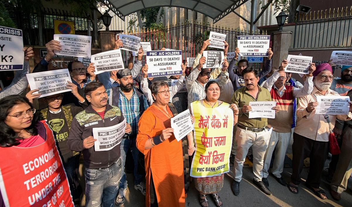 PMC bank account holders display placards as they protest outside the RBI building over the bank's crisis. (PTI Photo)