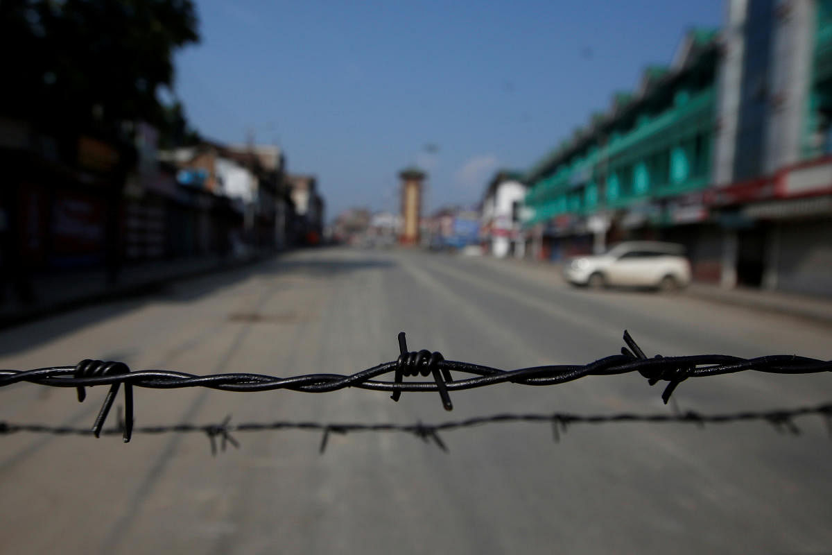 Barbed wire is seen laid on a deserted road during restrictions in Srinagar. (PTI Photo)