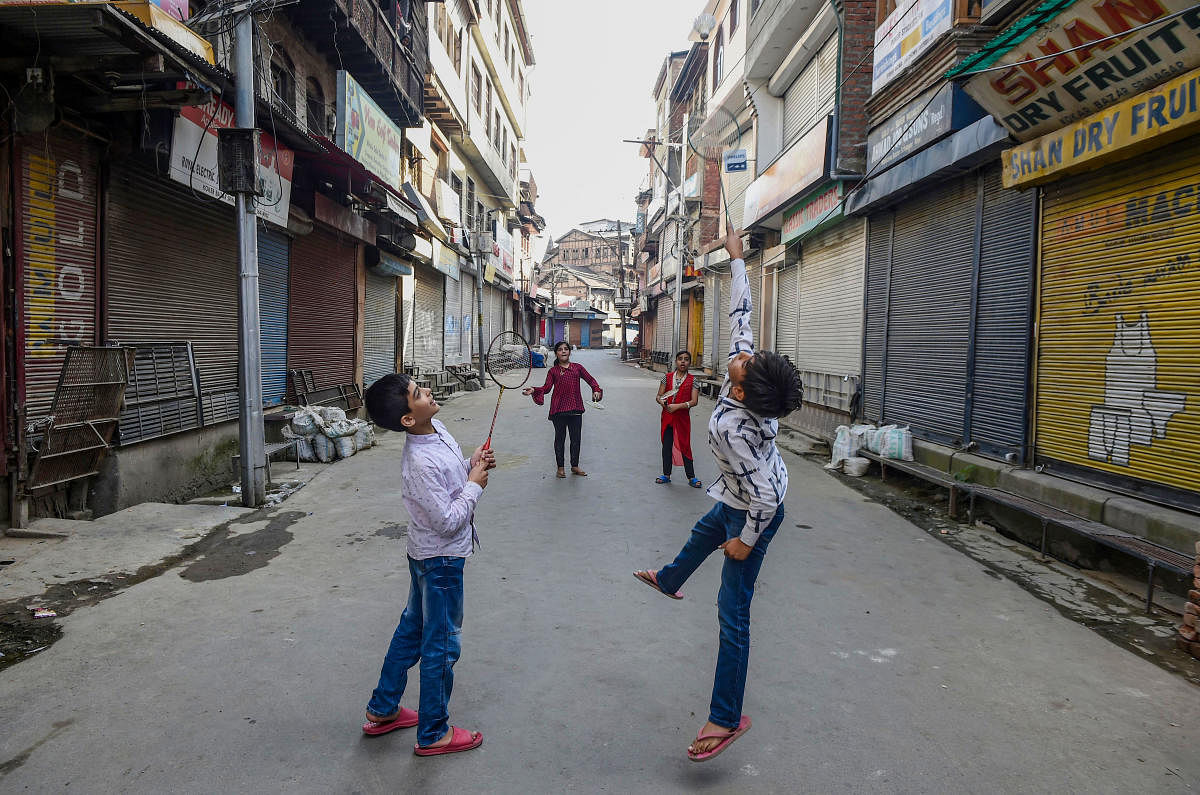 Children play badminton at a market during shutdown in Srinagar. (PTI Photo)