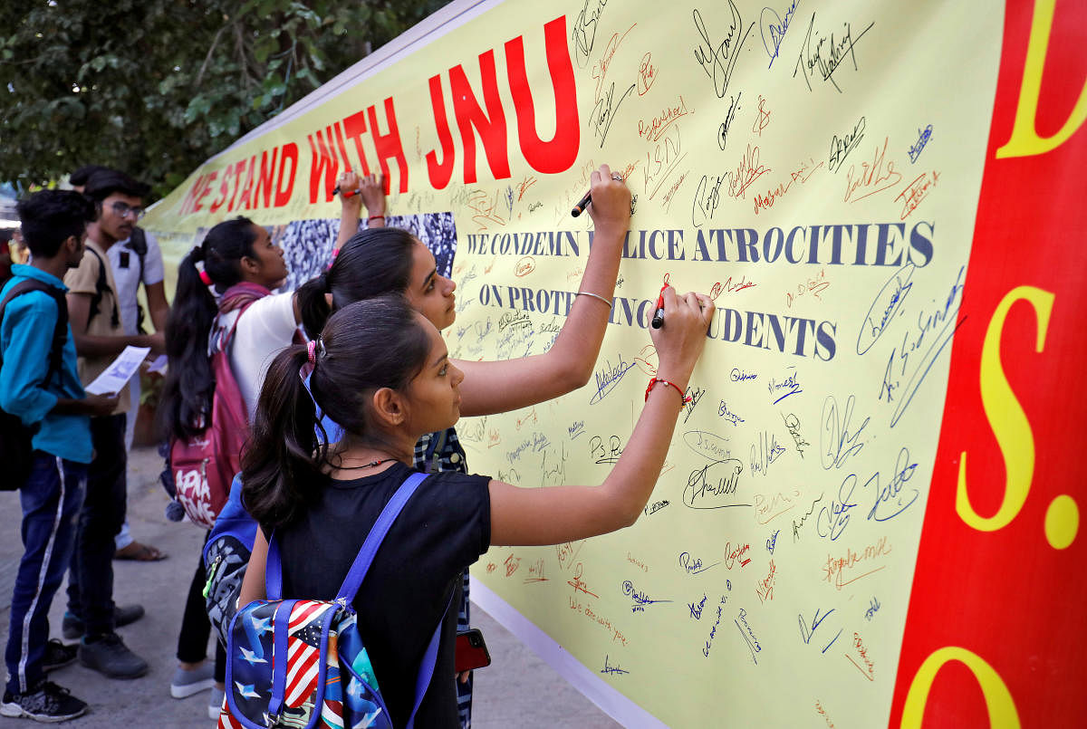 Students sign a banner during a signature campaign to show solidarity with the students of Jawaharlal Nehru University and to protest against a proposed fee hike in the university. (Reuters Photo)