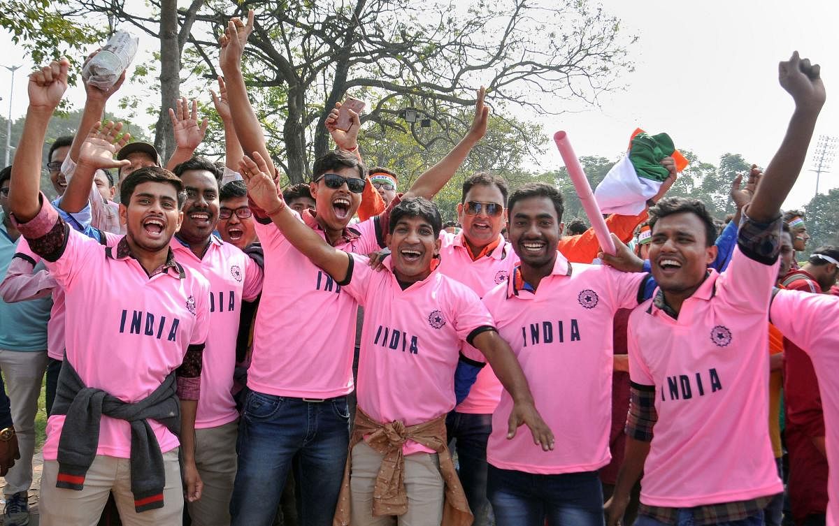 Cricket fans, wearing pink t-shirts, cheer as they arrive at the Eden Gardens to watch the historic day-night cricket test match between India and Bangladesh. Photo/PTI