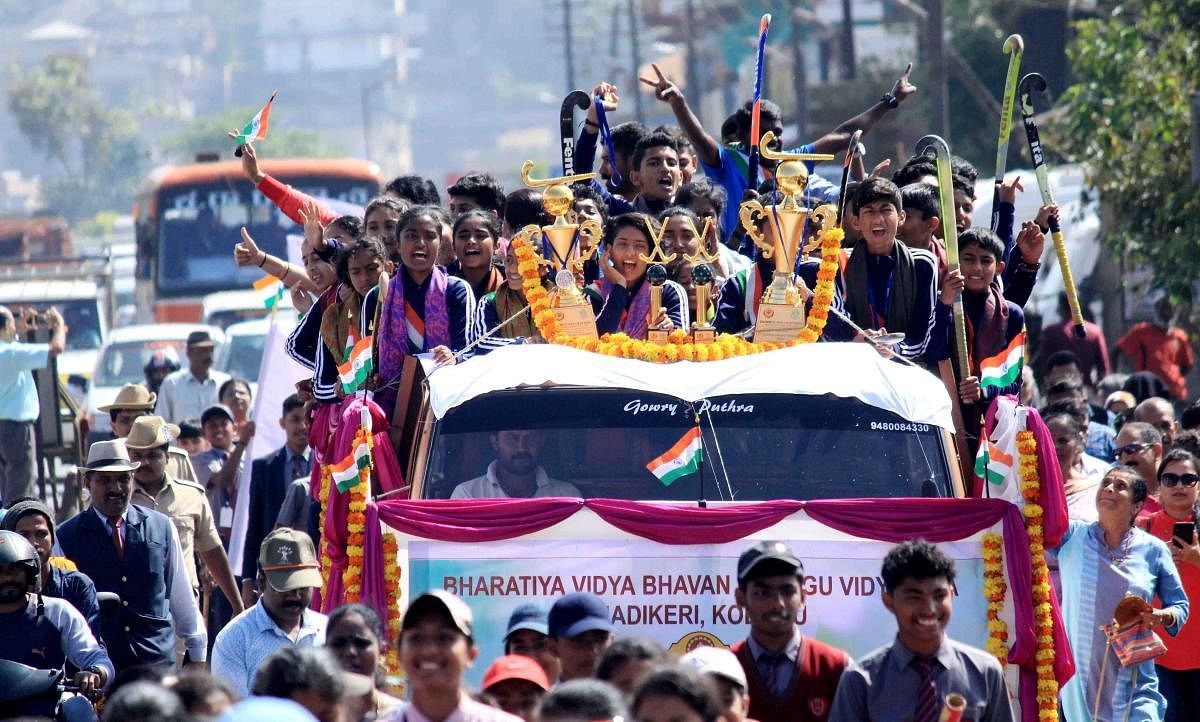 The winning teams go on a victory parade in an open vehicle in Madikeri on Friday.