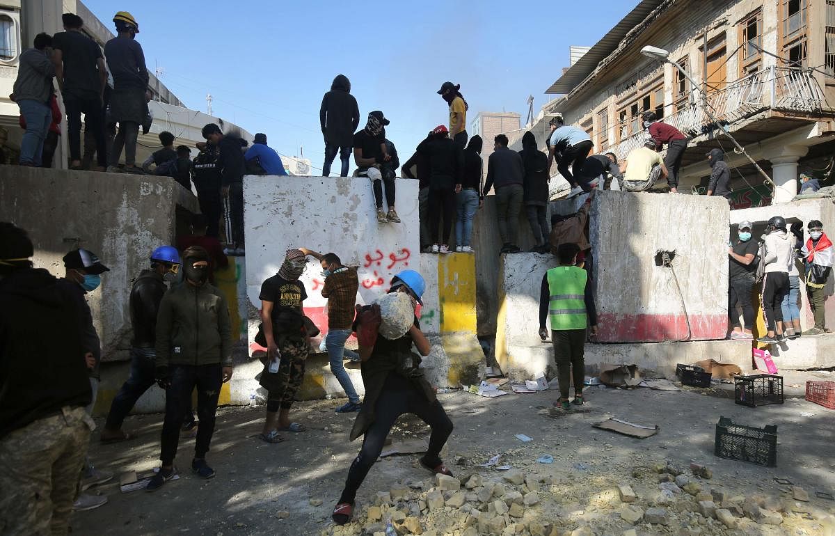 Iraqi anti-government protesters clash with security forces in al-Rasheed street near al-Ahrar bridge.  (Photo by AFP)