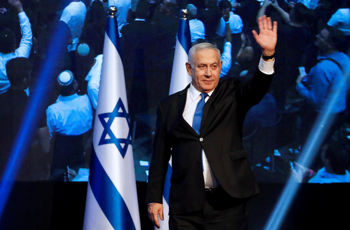 Israeli Prime Minister Benjamin waves to supporters at the Likud party headquarters.