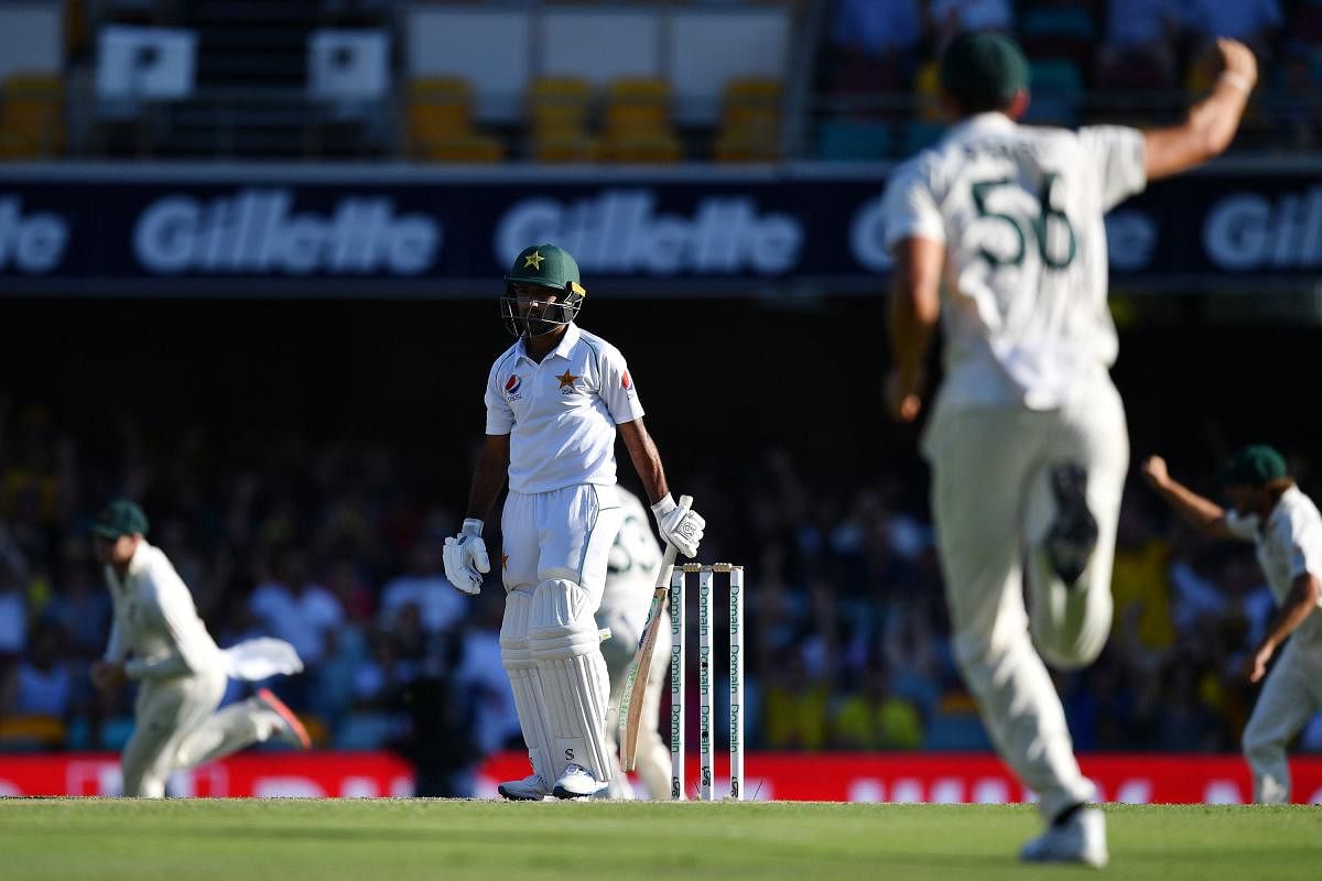 Pakistan's batsman Asad Shafiq (C) reacts after his dismissal as Australia's players celebrate on day three of the first Test cricket match between Pakistan and Australia at the Gabba in Brisbane (AFP Photo)