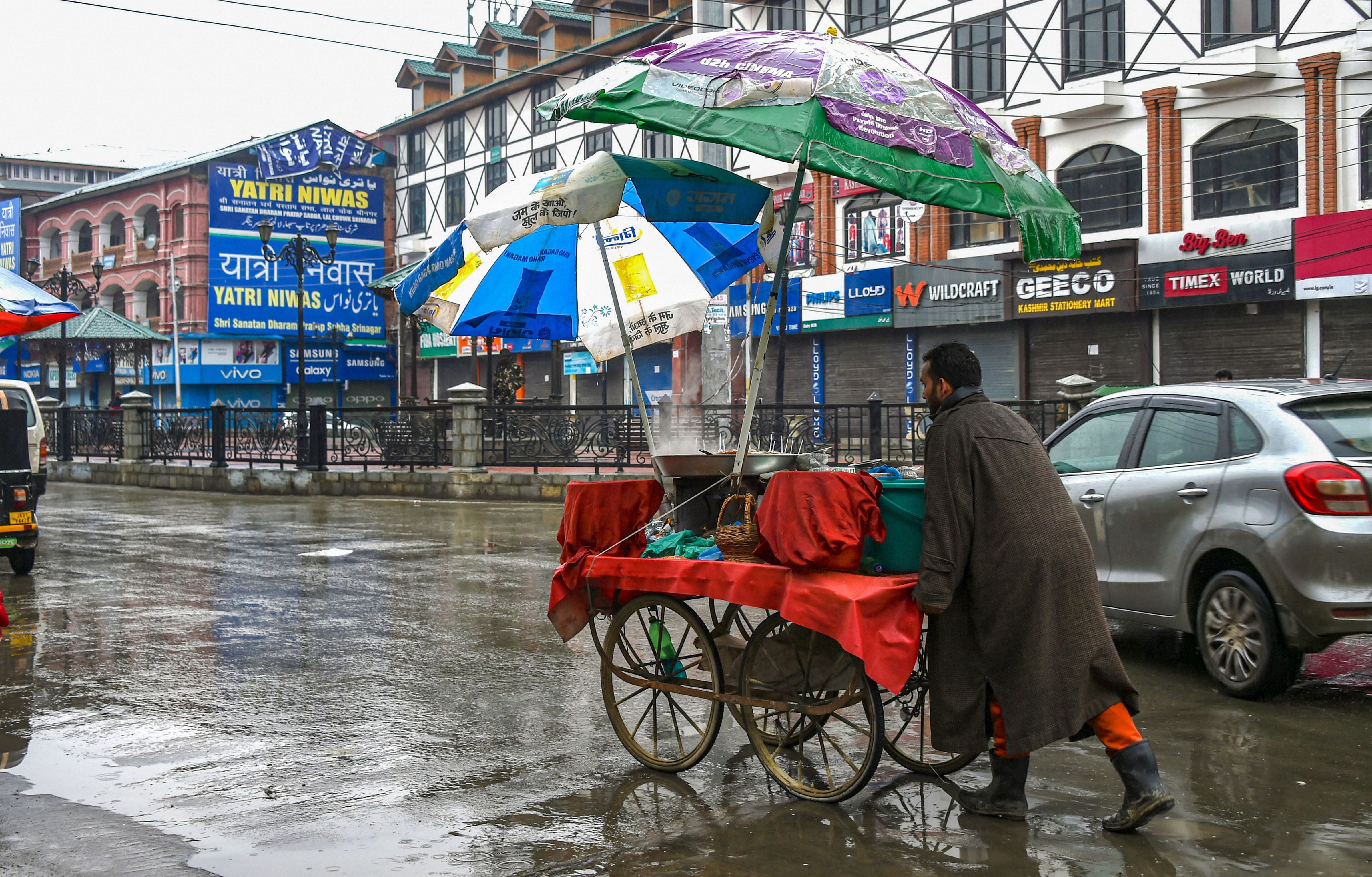 A street vendor pushes his cart across a deserted street during shutdown, in Srinagar. (PTI Photo)