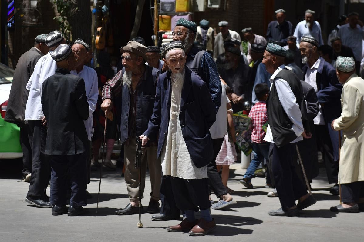 Uighur men are seen leaving a mosque after prayers in Hotan in China's northwest Xinjiang region. (AFP Photo)
