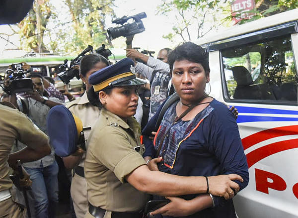 Activist Bindu Ammini is being escorted by police after a protest by various Hindu organizations outside police commissioner's office, in Kochi, Tuesday, Nov. 26, 2019. (PTI photo)