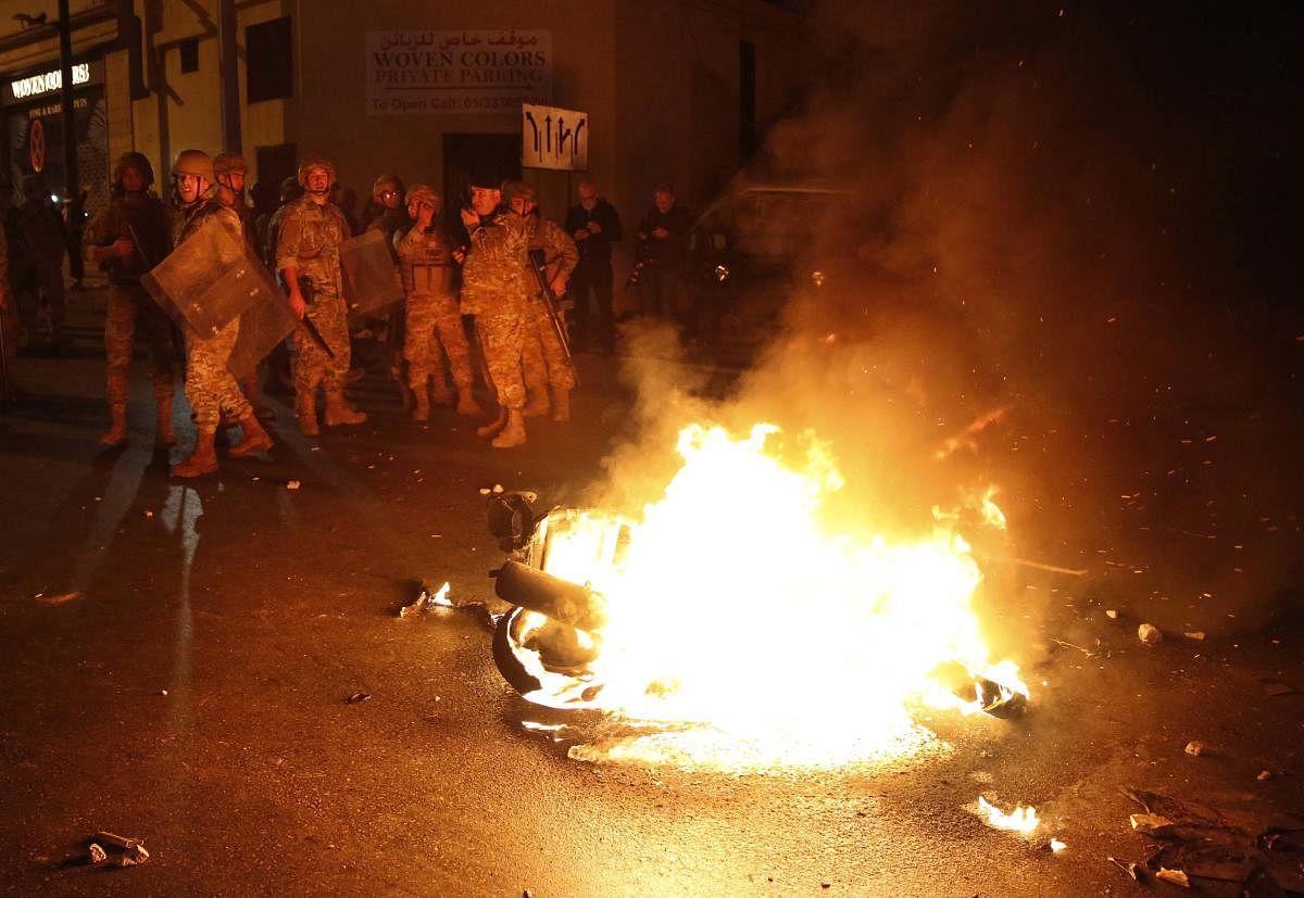  Lebanese army soldiers stand near a motorcycle that was set on fire by protesters. (AP Photo)