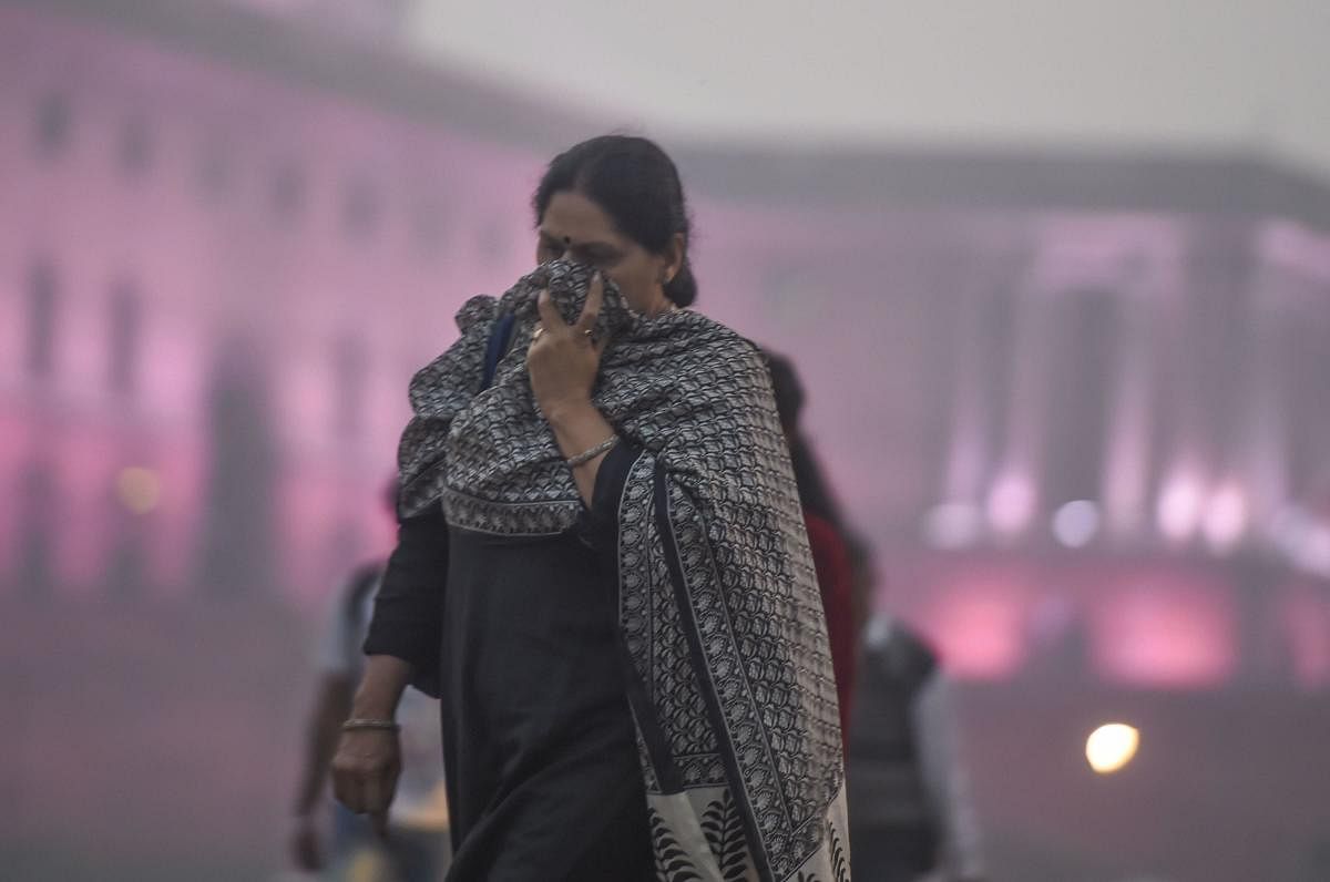 Pedestrian cover their face amid heavy smog as the air quality further dips to 'severe' category. PTI 