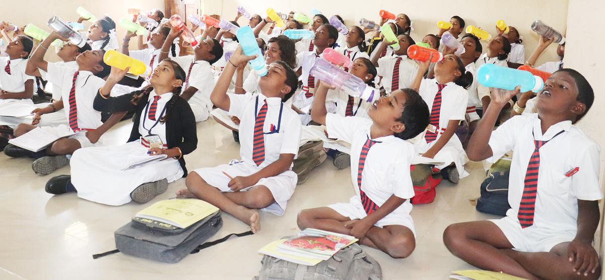 Children of Government Higher Primary School at Narayanapur in Gadag district drink water during a water break. The water bell in the school rings thrice a day.