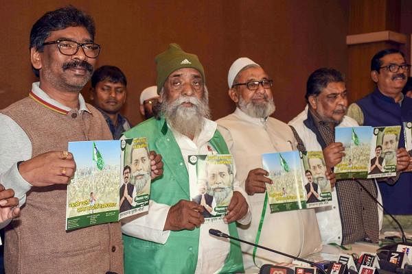 JMM Supremo Shibu Soren with former CM Hemant Soren (L) and other leaders releases their party menifesto for the Assembly elections, in Ranchi, Tuesday, Nov. 26, 2019. (PTI Photo)