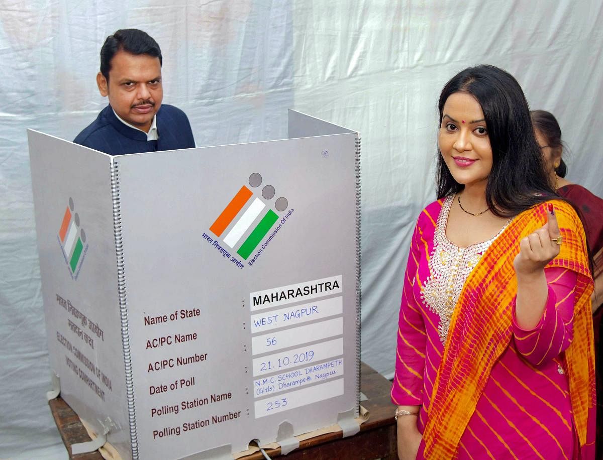Former Maharashtra Chief Minister and Nagpur BJP candidate Devendra Fadnavis casts his vote while his wife Amruta shows her inked finger after casting vote during the Maharashtra Assembly elctions, in Nagpur. (PTI Photo)