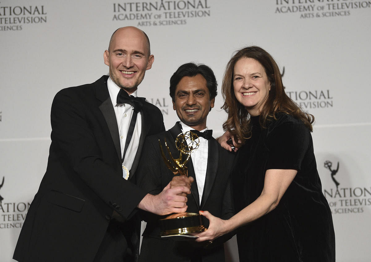 Executive producer/director/writer James Watkins, left, actor Nawazuddin Siddiqui and executive producer Dixie Linder pose with the best drama series award for "McMafia," during the 47th International Emmy Awards. (PTI Photo)