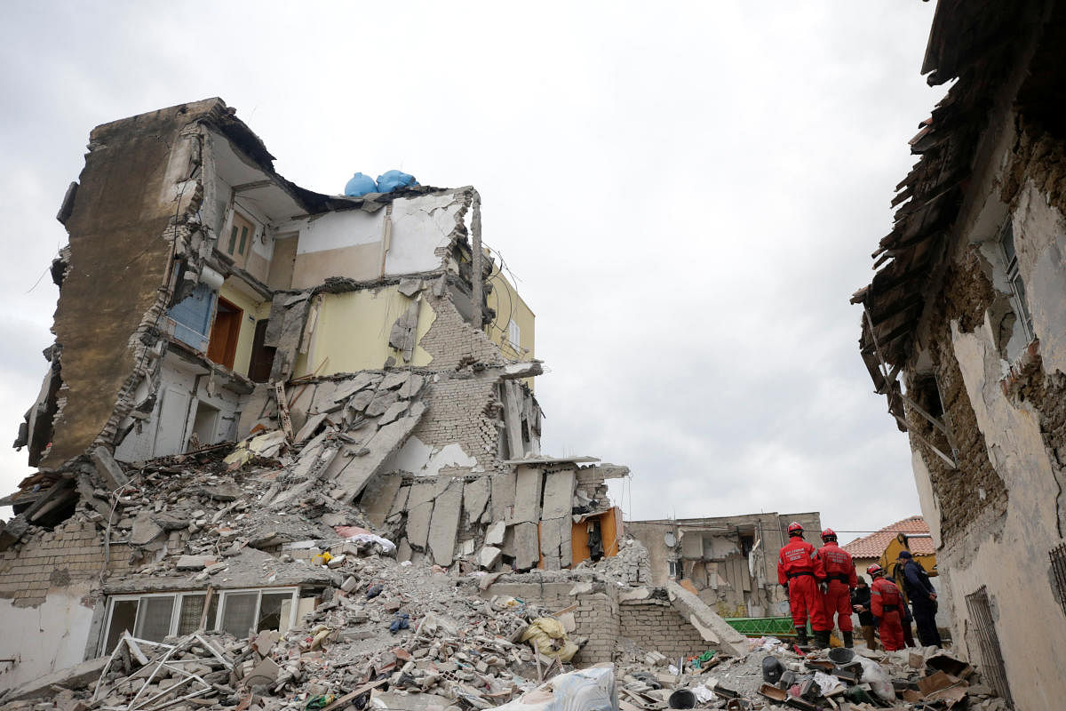 Emergency personnel stands on debris of collapsed and damaged buildings following Tuesday's powerful earthquake in Thumane, Albania. Photo by REUTERS